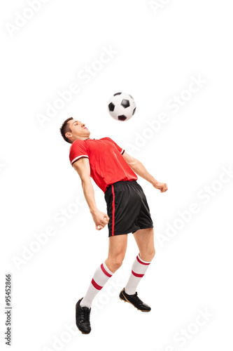 Young sportsman in red jersey playing football