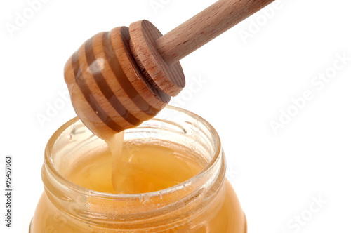 Cuillère à miel trempée dans un pot de miel