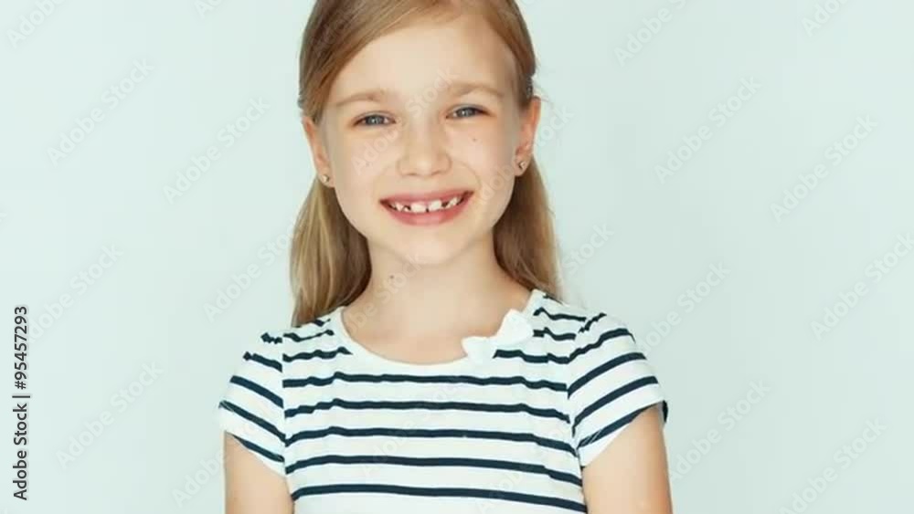 Closeup portrait girl child turns around head and smiling at camera Closeup portrait girl child turns around head and smiling at camera