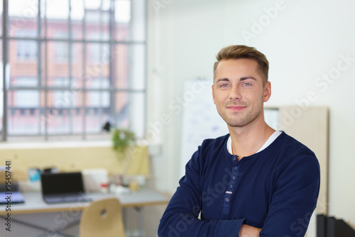 mann im büro mit verschränkten armen