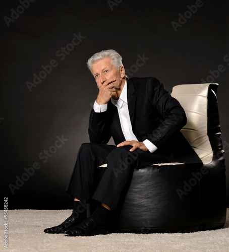  Thinking mature businessman sitting in chair photo