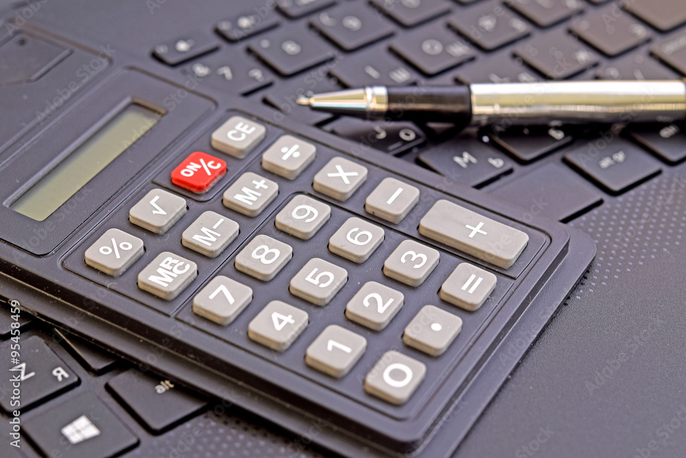 calculator, ballpoint pen and laptop keyboard calculator, ballpoint pen and laptop keyboard