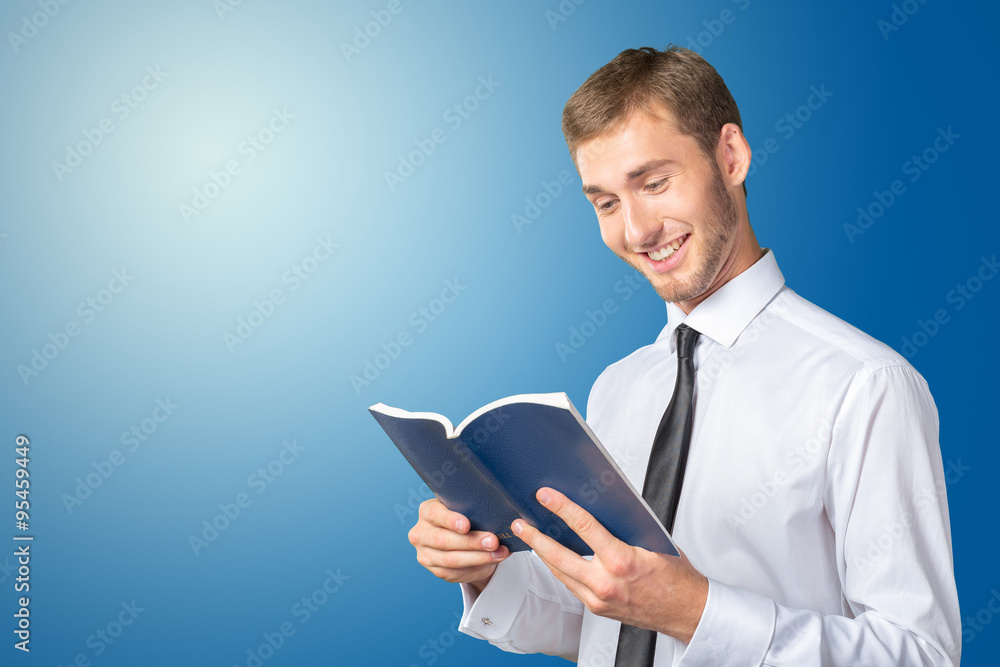 Handsome young business man reading a book