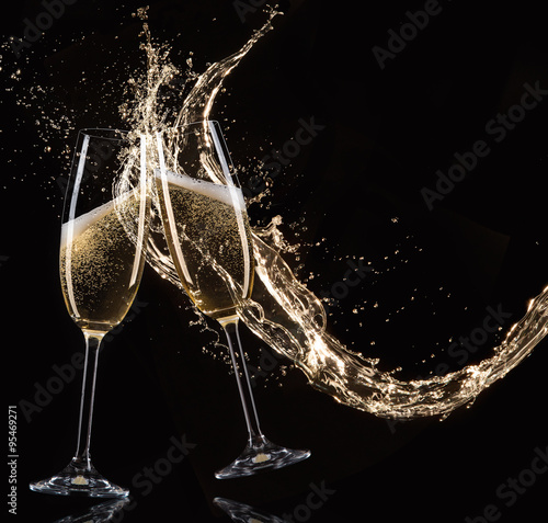 Glasses of champagne with splash, celebration theme.