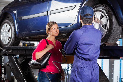 Customer Looking At Mechanic Refilling Car Tire