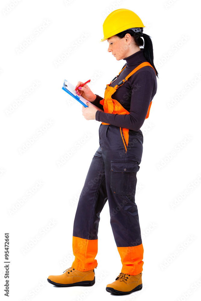 Attractive woman builder with notepad in hand, yellow helmet, orange boots and blue overall, concentrate on the job, makes decision, positive human emotions, isolated white background. Attractive woman builder with notepad in hand, yellow helmet, orange boots and blue overall, concentrate on the job, makes decision, positive human emotions, isolated white background.