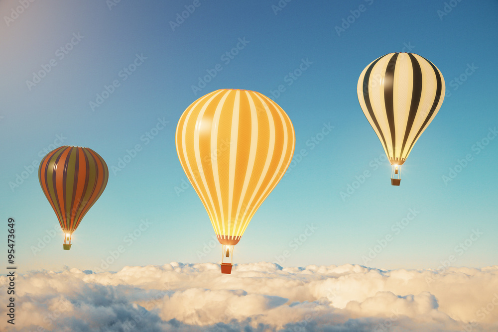 Naklejka premium Trzy balony nad chmurami o zachodzie słońca