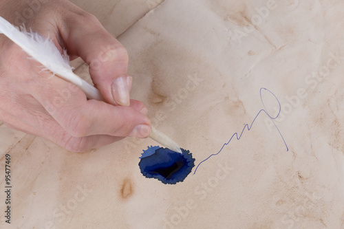 weibliche Hand Unterzeichnet mit einer Feder auf dem alten Papier