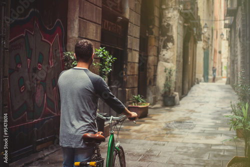 Young male is riding a bicycle in Barcelona
