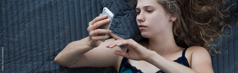 Woman texting in bed