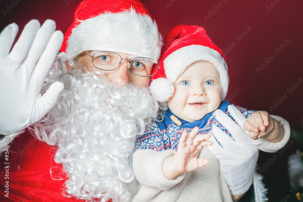 Happy baby and Santa Claus say hello and wave hand Happy baby and Santa Claus say hello and wave hand