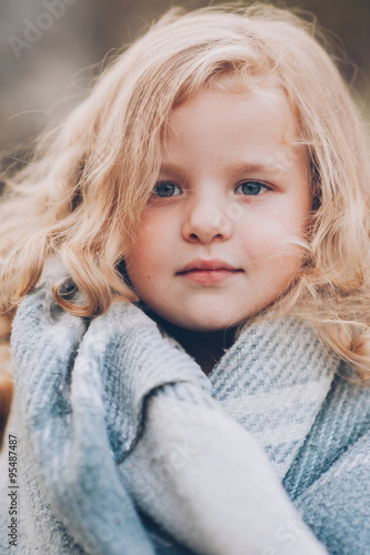 Adorable girl stay covered with blanket in park