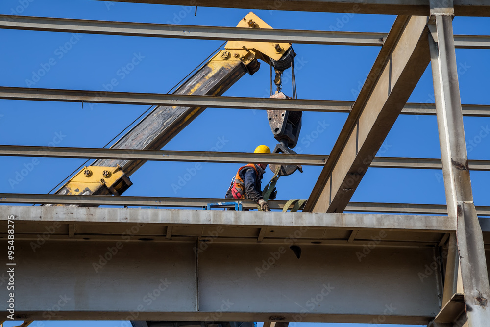 Worker high above dissembling metal structure Worker high above dissembling metal structure