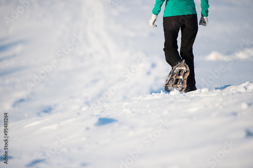 Junge Frau mit Schneeschuhen im Winter