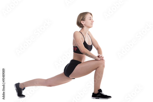 Fototapeta Naklejka Na Ścianę i Meble -  Sporty woman doing high lunges