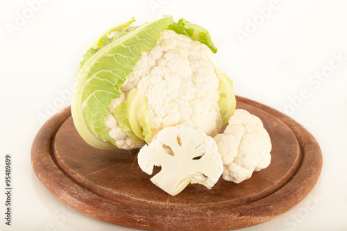 Head of fresh cauliflower on wooden cutting board