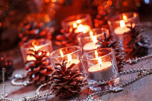 Christmas and New Year's background with candles, fir cones and