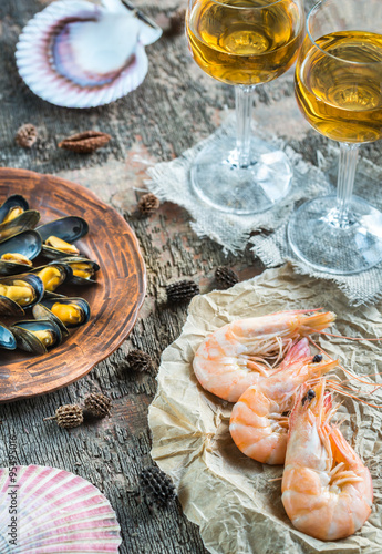 Seafood with two glasses of white wine on the wooden table