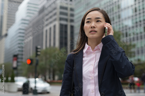 Asian business woman in New York City talking cell phone