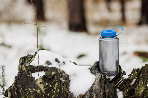 A bottle of cold water on wood with winter scene background