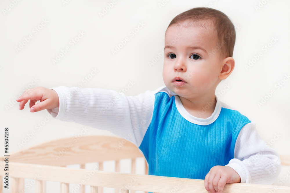 Adorable baby toddler indicates with hand and finger on white background Adorable baby toddler indicates with hand and finger on white background