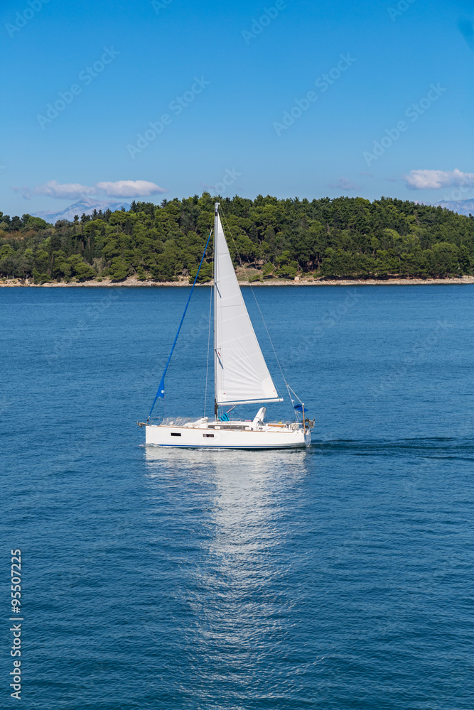 Obraz premium Sailing boat on blue sea waters with clear blue sky