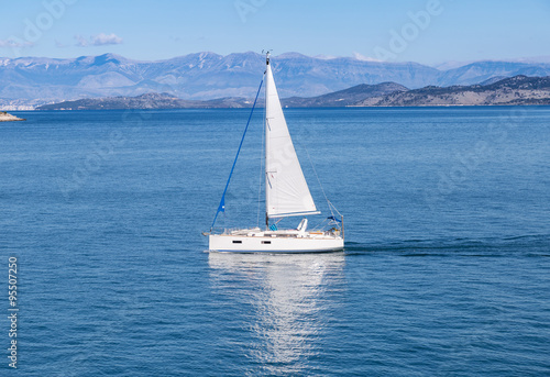 Sailing boat on blue sea waters with clear blue sky