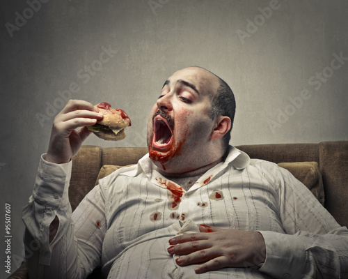 Fotografi Voracious man eating a hamburger