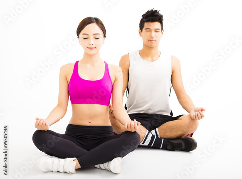 young couple practicing yoga isolated on white