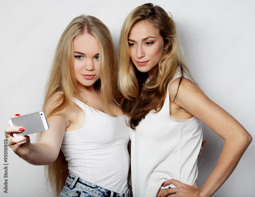 two young women taking selfie with mobile phone two young women taking selfie with mobile phone