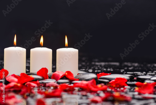 Red rose petals with three candle and therapy stones 