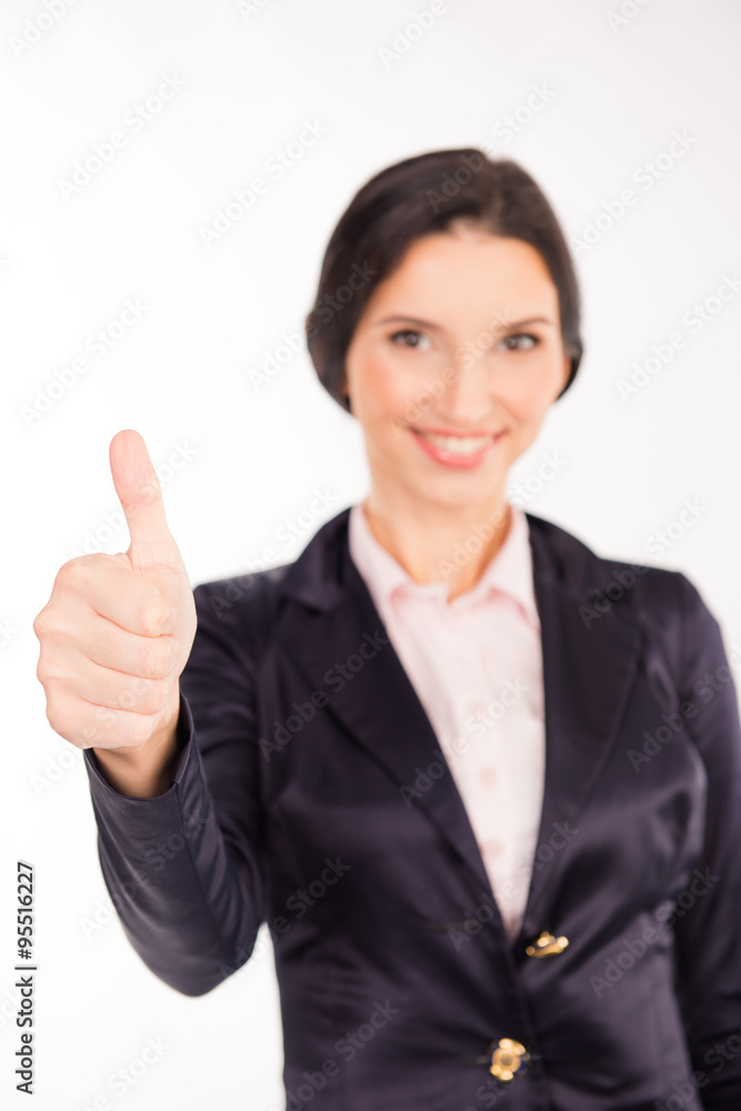 Well done! Beautiful young woman in formalwear showing her thumb Well done! Beautiful young woman in formalwear showing her thumb