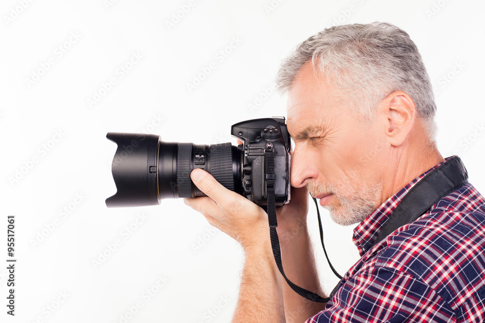 Side view of aged photographer making a photo Side view of aged photographer making a photo
