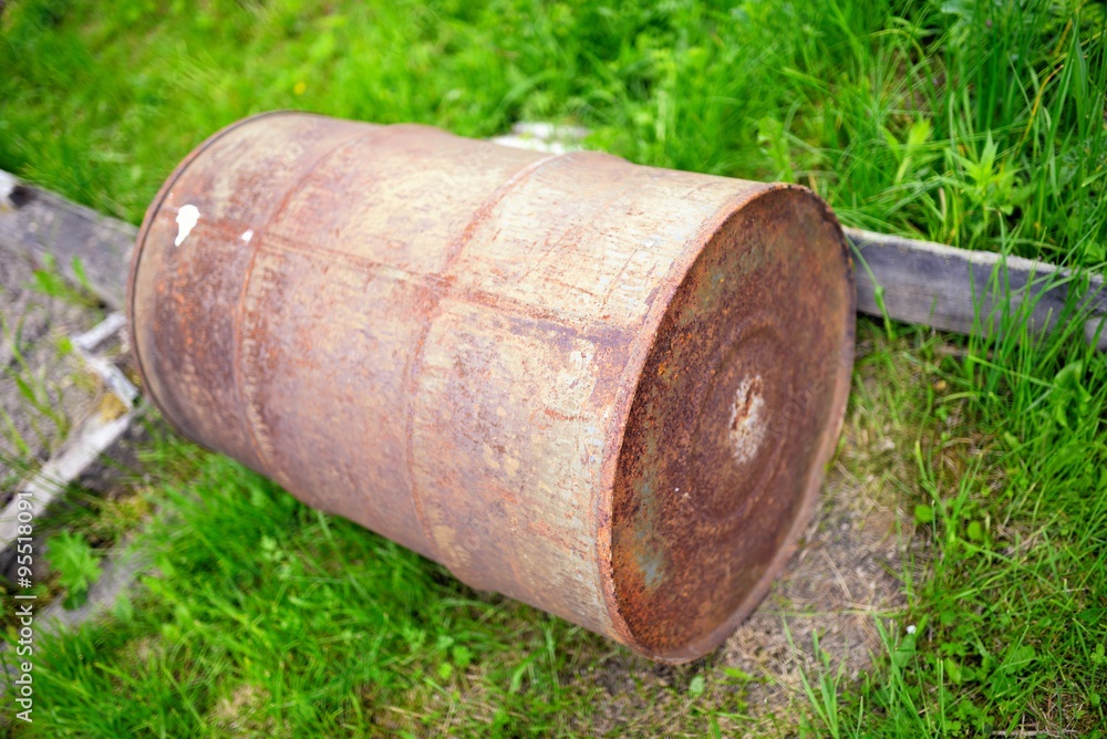 Old rusty barrel against a green grass Old rusty barrel against a green grass