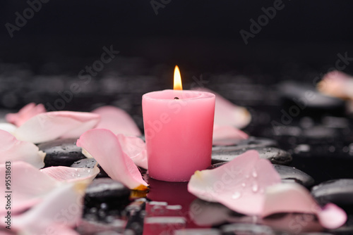 Still life with rose petals with pink candle and therapy stones 