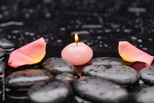 Still life with pink rose petals with candle and therapy stones 