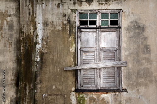 old window in an ancient brick wall in an abandoned farm barn, with dingy light for copy space photo