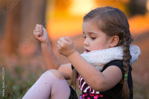 a little girl is trying to fix her hole in her tights