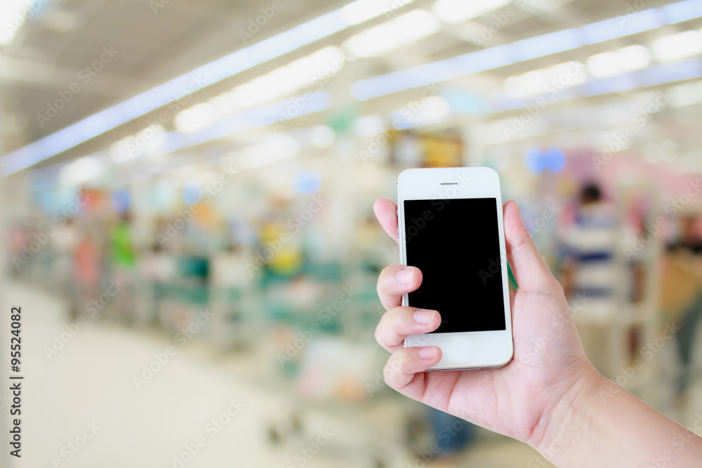 Hand use smartphone with Supermarket store background ,Cashier c Hand use smartphone with Supermarket store background ,Cashier c