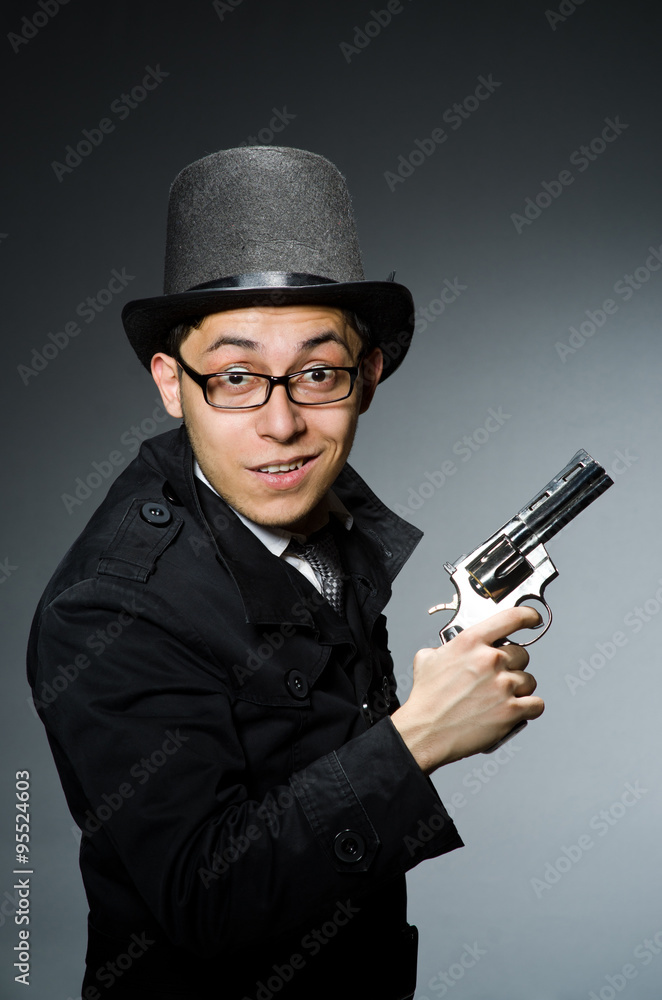 Criminal in black coat holding hadgun against gray Criminal in black coat holding hadgun against gray