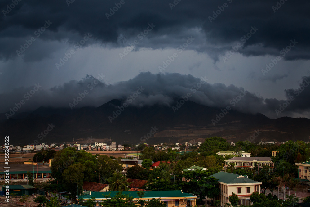 upper view of city dark thunderclouds above city mountains