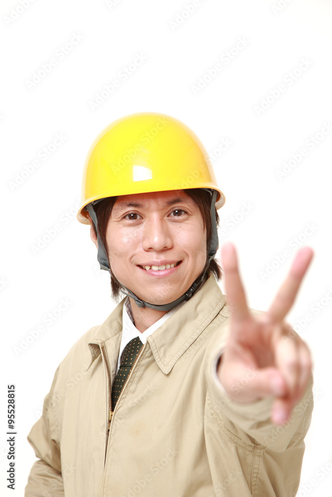 young Japanese construction worker showing a victory sign