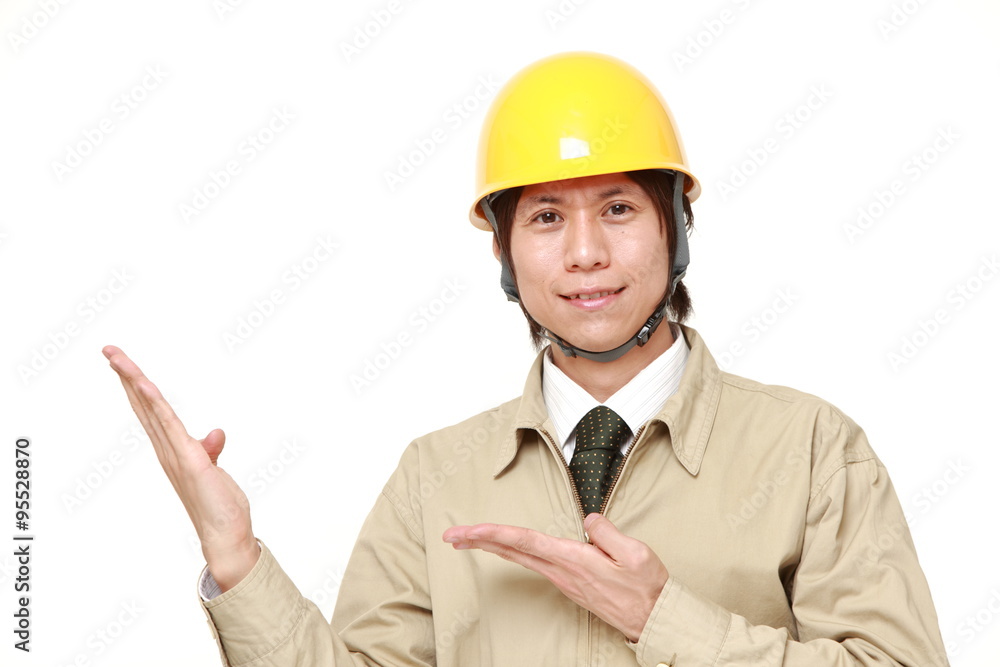 young Japanese construction worker presenting and showing something young Japanese construction worker presenting and showing something
