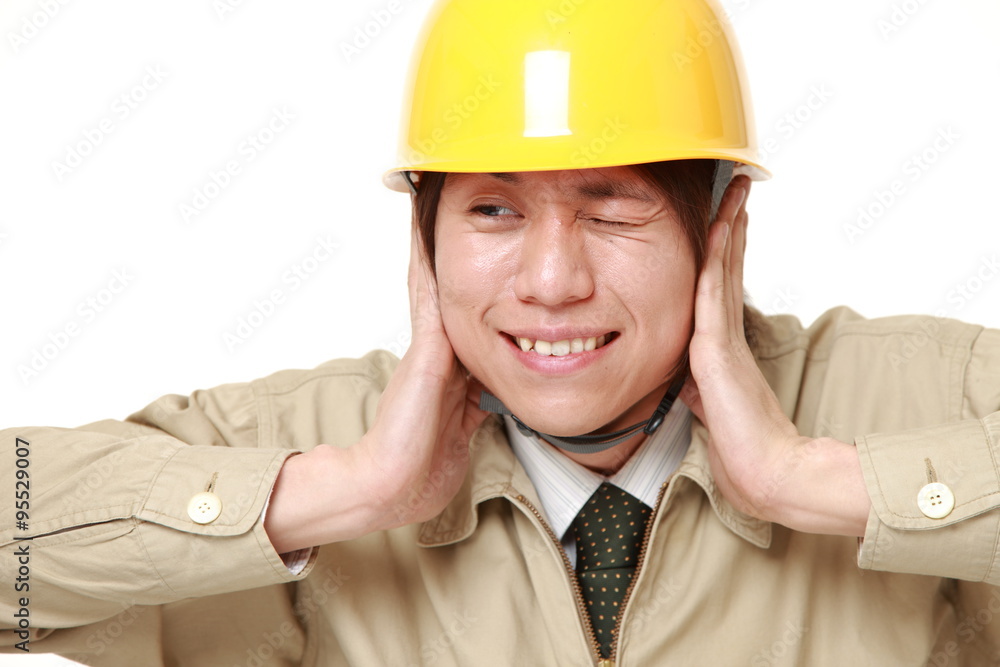 Young Japanese construction worker suffers from noise Young Japanese construction worker suffers from noise