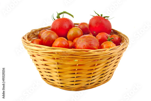 Organic tomatoes in basket isolated on white background