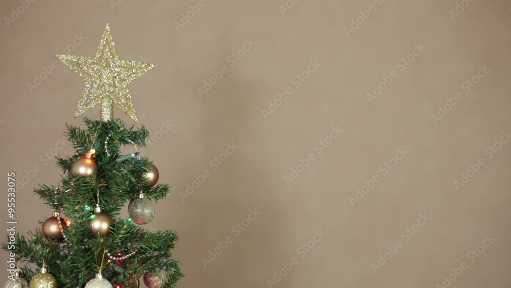 Artificial Christmas tree detail with golden decorations and lights, pan movement. Artificial Christmas tree detail with golden decorations and lights, pan movement.