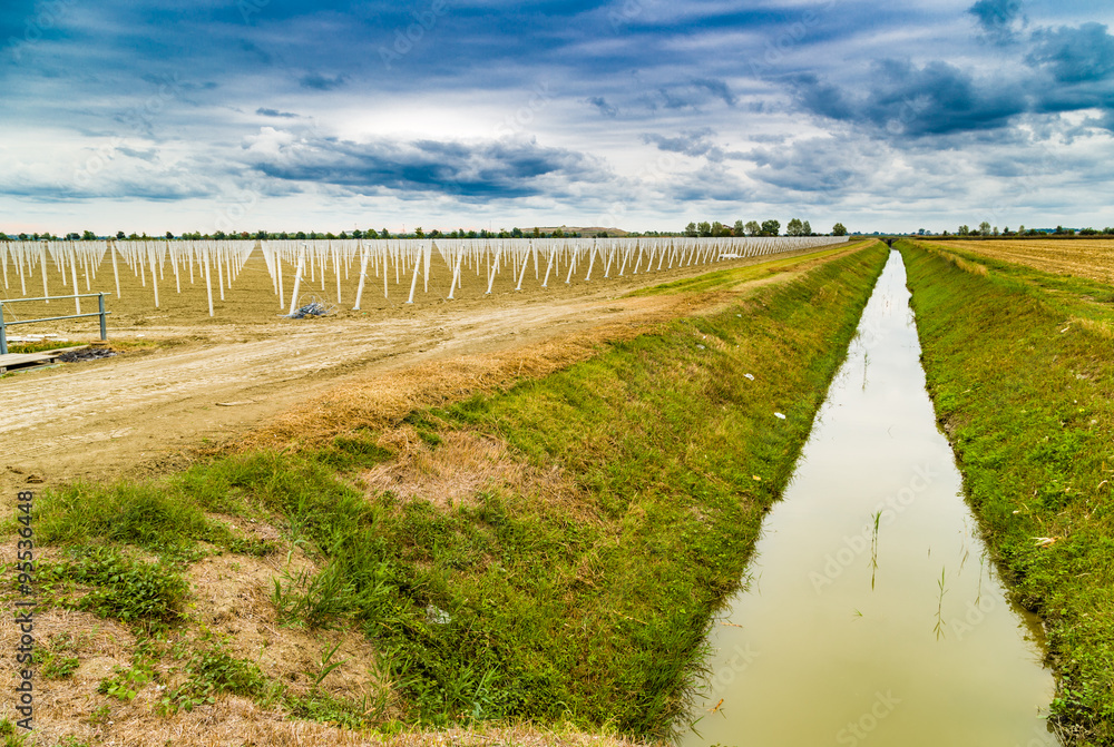 irrigation canal divides harvested land  and plowed land with pr