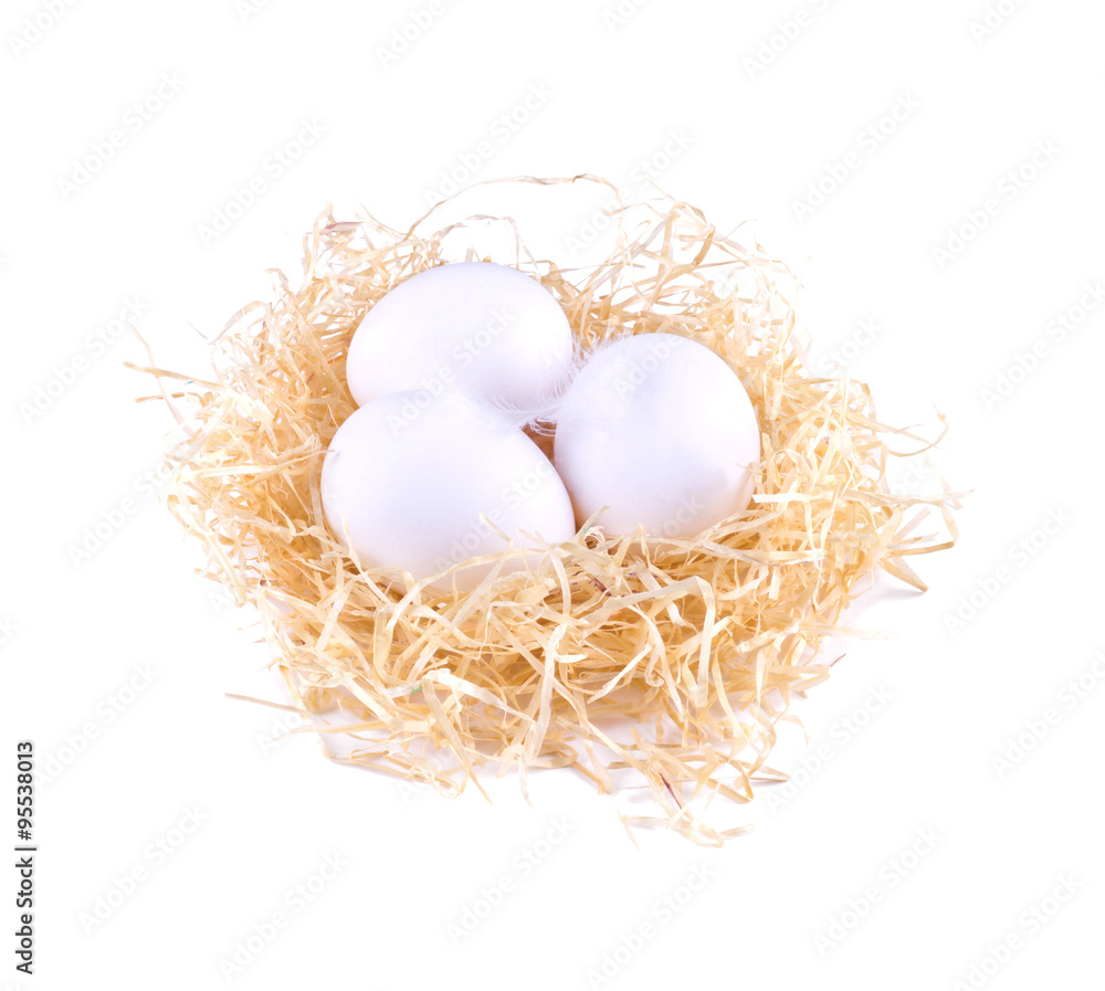Three white eggs in the straw. White eggs in the nest isolated. Three white eggs in the straw. White eggs in the nest isolated.
