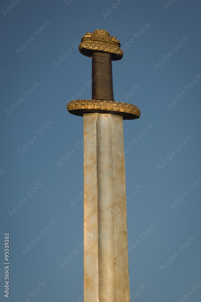 Medieval viking sword against a blue sky