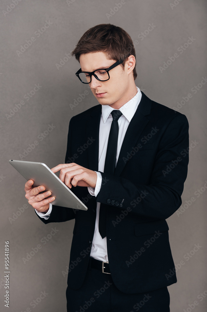Examining his new tablet. Examining his new tablet.